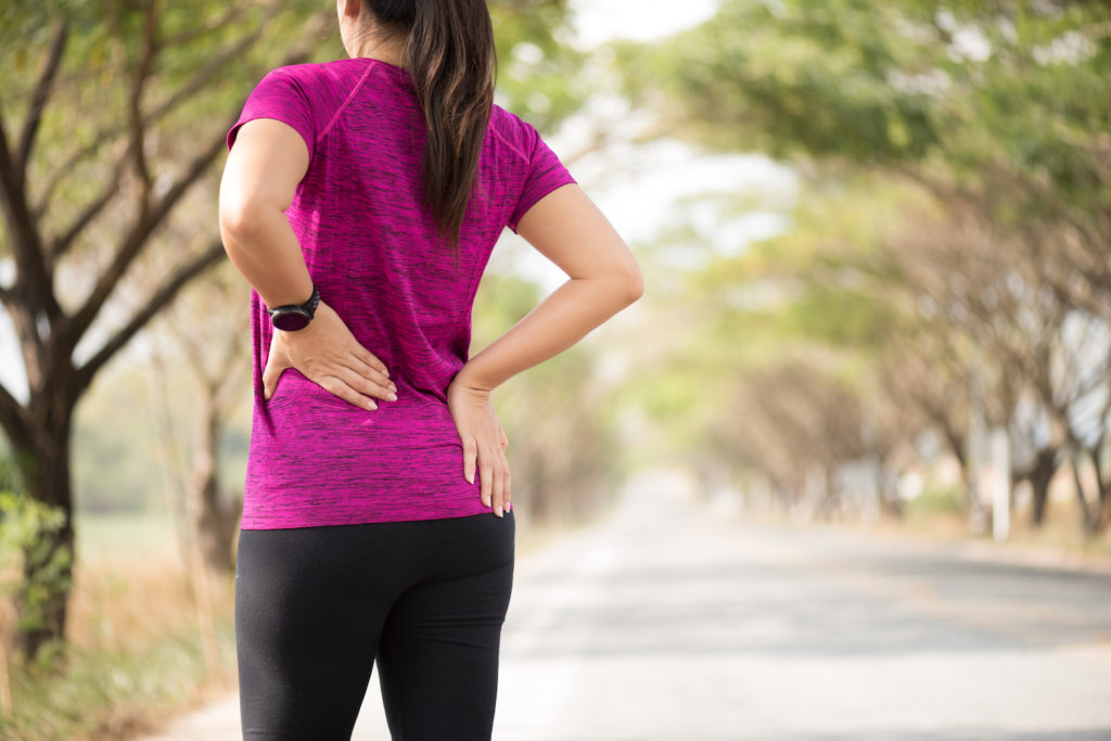 woman wearing purple shirt suffer from back [ain