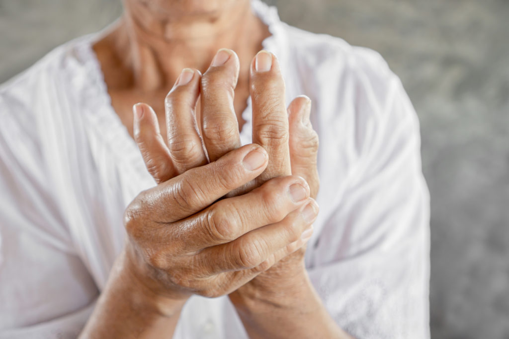 old woman holding her hands due to pain