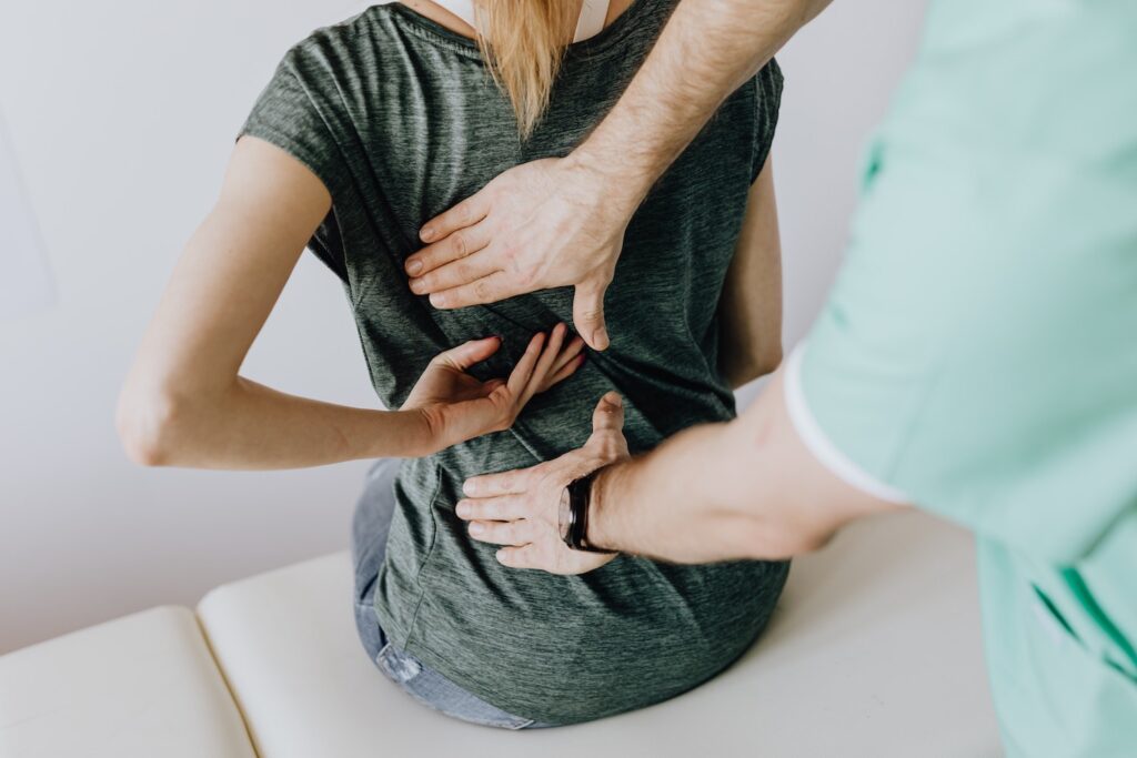 chiropractor checking on patient lower back pain